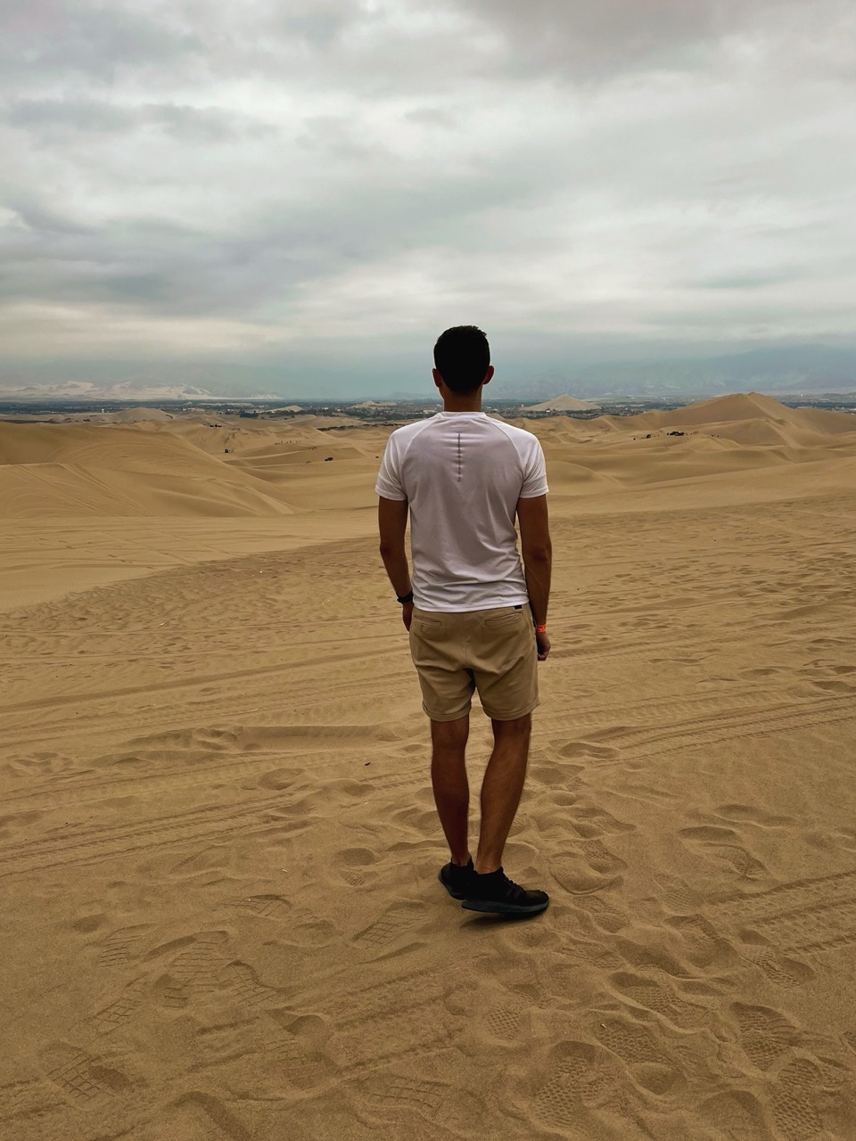 On the ridge of the sand mountain, dunes rolling to the horizon